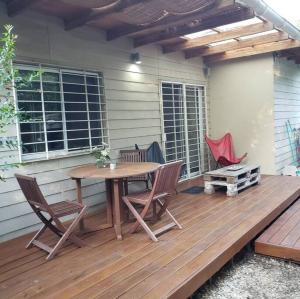 una terraza de madera con mesa y sillas. en La Fortunata, en Maldonado