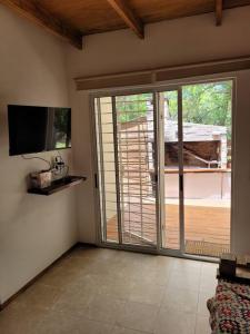 una sala de estar con una puerta corredera de cristal que da a una terraza en La Fortunata, en Maldonado