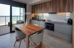 a kitchen with a wooden table and some chairs at Floryda Gardenia Seaside in Dziwnów