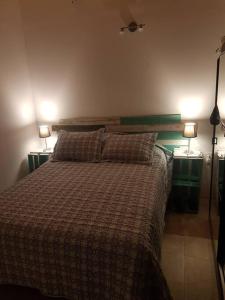 1 dormitorio con 1 cama con 2 lámparas en 2 mesas en La Fortunata, en Maldonado