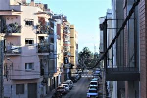 a city street with parked cars and buildings at Apartamento Sofia in Pineda de Mar