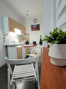uma cozinha com armários brancos e uma mesa e cadeiras em Studio Piekary 1-go Maja em Piekary Śląskie