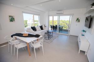 a living room with a white couch and a table and chairs at 3 ambientes en Complejo de Lujo in Pinamar +10 photos
