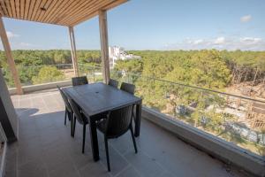 a black table and chairs on a balcony with a view at 3 ambientes en Complejo de Lujo in Pinamar