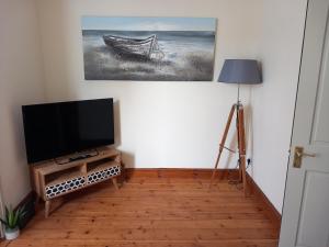 uma sala de estar com uma televisão de ecrã plano e um candeeiro em Belv House em Weymouth