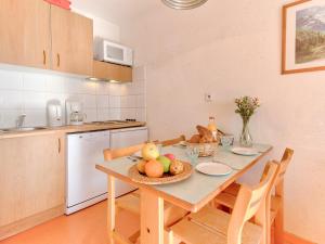 una cocina con una mesa con un bol de fruta. en Vacancéole - Les Balcons du Soleil, en Germ
