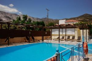 a swimming pool with chairs and mountains in the background at Stella Apartments in Marathokampos +29 photos