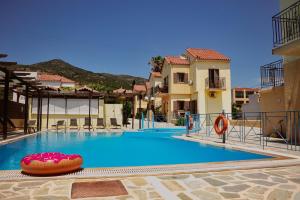 a swimming pool with a raft in the middle at Stella Apartments in Marathokampos