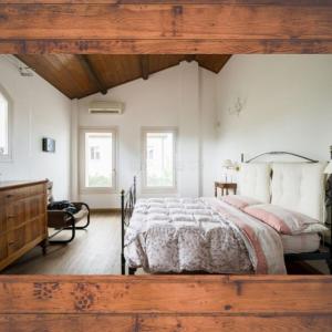 a bedroom with a large bed with a wooden ceiling at La Fornace in Il Palazzone