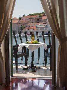 a table with a plate of food and drinks on a balcony at Villa Slika in Milna