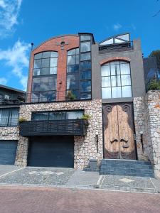 a brick building with two garage doors and a wooden door at Eagles Nest in Cape Town