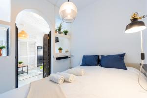 een slaapkamer met een wit bed met blauwe kussens bij Congresos Centro in Torremolinos