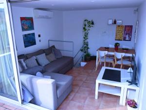 ein Wohnzimmer mit einem Sofa und einem Tisch in der Unterkunft El Terrat de la Tecla - Dúplex Casc Antic in Tarragona