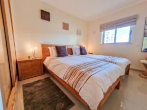 a bedroom with a large bed and a window at Apartment Rocha Oceano Azul Charming in Portimão