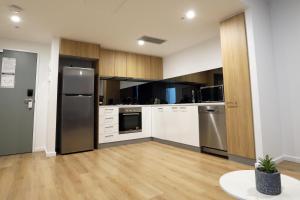 a kitchen with white cabinets and stainless steel appliances at CBD Stunning TOP Floor View - FREE Parking FREE Netflix FREE Gym FREE Pool FREE Sauna FREE BBQ Area FREE Coffee in Adelaide