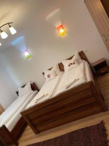 a bedroom with two beds with white sheets and pillows at Pensiunea Carmen 