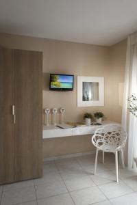 a bathroom with a table and a tv on the wall at Frau Irenes Haus in Sarti