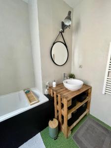 uma casa de banho com um lavatório, uma banheira e um espelho. em L'appartement Mersois - 50m de la mer & cosy em Mers-les-Bains