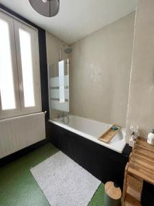 uma casa de banho com uma banheira e uma janela em L'appartement Mersois - 50m de la mer & cosy em Mers-les-Bains