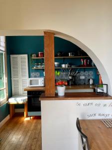 een keuken met een boog over een aanrecht in een kamer bij L'appartement Mersois - 50m de la mer & cosy in Mers-les-Bains