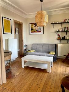 uma sala de estar com um sofá e uma mesa de centro em L'appartement Mersois - 50m de la mer & cosy em Mers-les-Bains