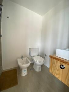 y baño con aseo y lavamanos. en 126 Suite Centro II en Suipacha