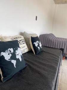 a bed with two black and white pillows on it at 126 Suite Centro II in Suipacha