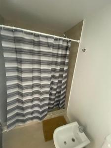 y baño con cortina de ducha y aseo. en 126 Suite Centro II en Suipacha