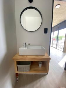 baño con lavabo y espejo en la pared en 126 Suite Centro II en Suipacha