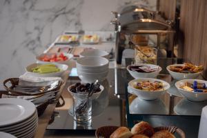 una línea de buffet con platos y tazones de comida en Hotel Eterno, en Strumica