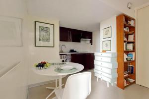 - une cuisine avec une table blanche et des chaises blanches dans l'établissement Loft Margutta per Smart Worker, à Rome