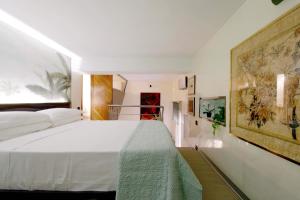 - une chambre avec un lit blanc et une peinture murale dans l'établissement Loft Margutta per Smart Worker, à Rome