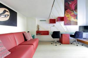 a living room with a red couch and two chairs at Loft Margutta per Smart Worker in Rome