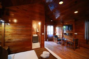 a room with wood paneled walls and a living room at Lazo Coffee Bean Resort in Madikeri