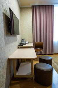 a room with a table and two chairs and a tv at Inga Hotel Yerevan in Yerevan