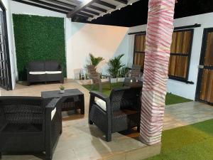 a patio with a table and chairs and a column at Malibu beach in Punta de Piedra