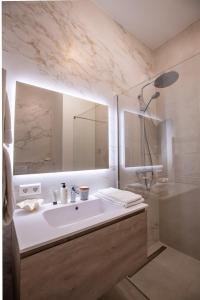 uma casa de banho com um lavatório branco e um chuveiro em The Harbour luxurious, use of hotel swimming pool and sauna em Cadzand