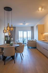 uma sala de jantar e sala de estar com mesa e cadeiras em The Harbour luxurious, use of hotel swimming pool and sauna em Cadzand