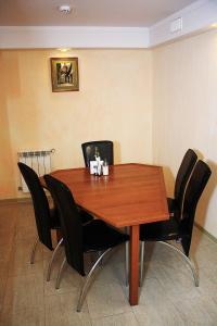 een eettafel met zwarte stoelen eromheen bij Hotel Strike in Vinnytsya