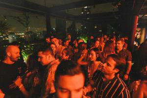 un grupo de personas de pie en una multitud en una fiesta en The Somos Beats Hotel & Rooftop, en Medellín