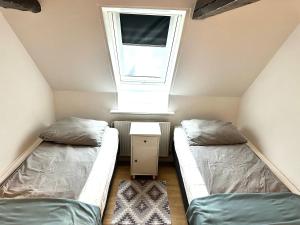 Duas camas num pequeno quarto com uma janela em Cozy one bedroom apartment near the sea em Tisvildeleje