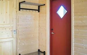 eine rote Tür in einem Zimmer mit einer Holzwand in der Unterkunft Lovely Apartment In Sandstad With Wifi in Skipnes