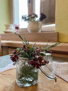 ein Mason-Glas mit Weihnachtsdekoration auf dem Tisch in der Unterkunft Wohlfühlherberge Weitblick in Erlbach