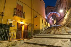 un callejón con un arco iluminado en una ciudad por la noche en B&B Antico Caricatore - Ex B&B Porta di Mare, en Sciacca