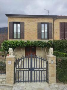 a black gate in front of a brick house at La casetta al Teatro Romano in Gubbio