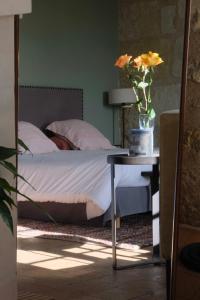 a bedroom with a bed and a table with a vase of flowers at Château de Nazelles Amboise in Nazelles