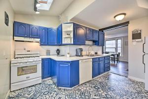 eine blaue Küche mit weißen Geräten und blauen Schränken in der Unterkunft Tonawanda Apartment Steps to Niagara River! in Tonawanda