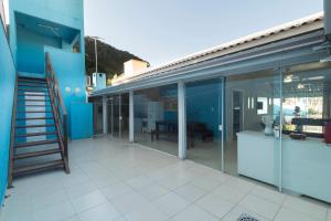 a balcony of a house with glass doors and a staircase at CASA COM PISCINA EM MORRINHOS - RUA HORTÊNCIA in Bombinhas
