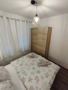 ein Schlafzimmer mit einem Bett mit einer blumengeschmückten Tagesdecke in der Unterkunft Apartment Ela, Kostrena Rijeka in Kostrena