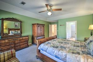 a bedroom with a bed and a dresser and a mirror at Lovely Hot Springs Home with Lake Balboa Access in Hot Springs Village